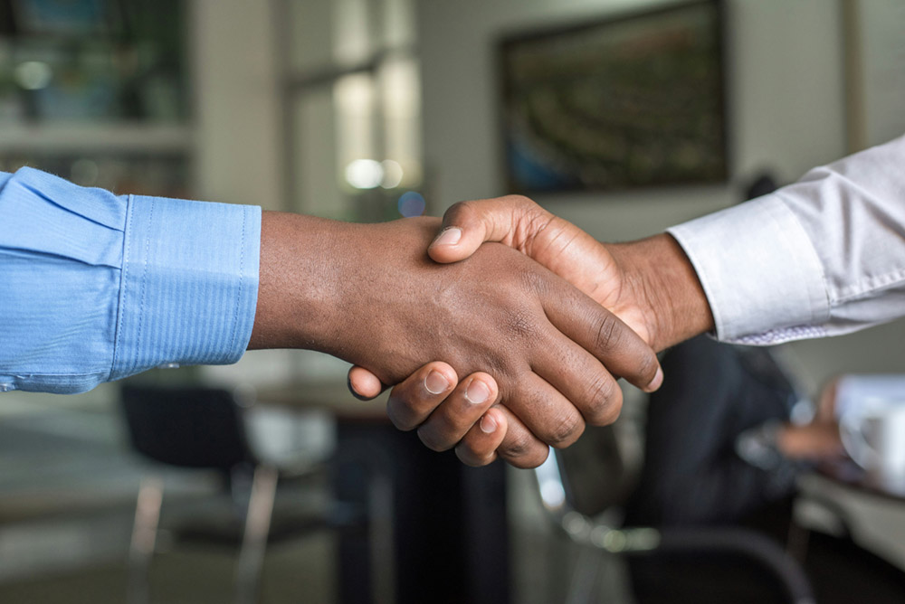 Photo of people shaking hands to show a partnership